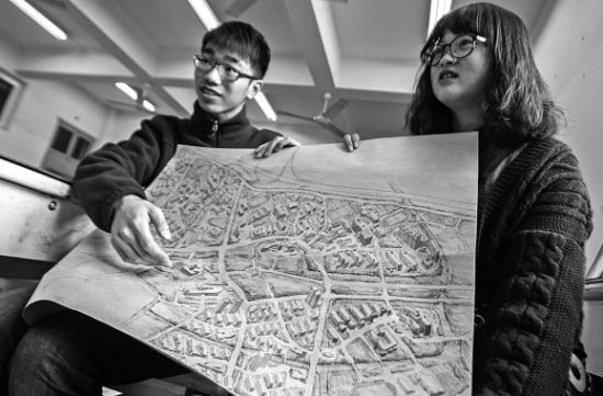 昨天上午，在MILE米乐集团，手绘图的作者郭龙(左)和何菡丹(右)在展示他们的创作手稿。 记者 姚卡/摄